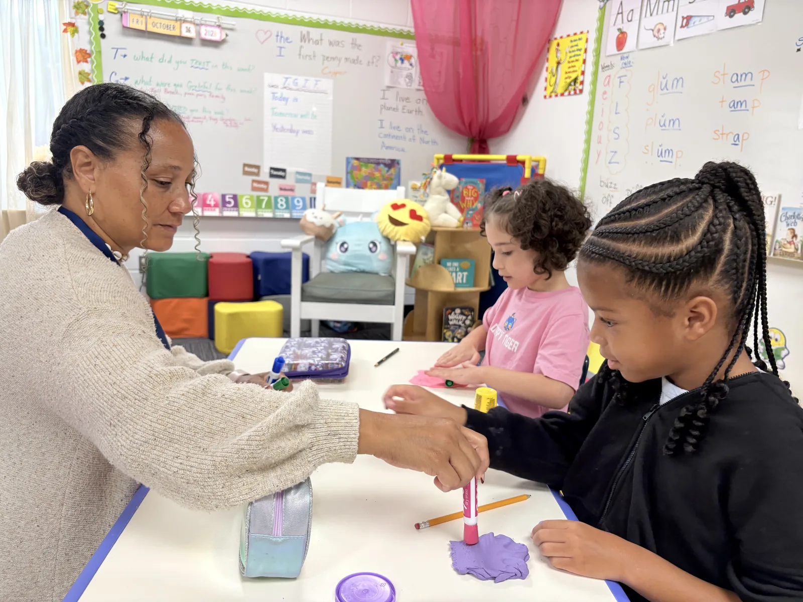 A Laurel teacher working with two students at a classroom table
