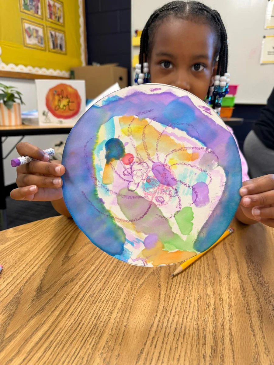 A Laurel student sharing a colorful art project