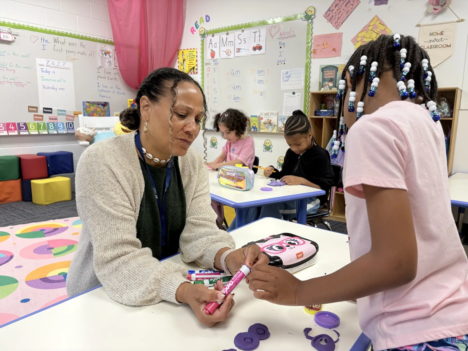 Mrs. Dews-Fowlkes working one-on-one with a Lower Elementary student