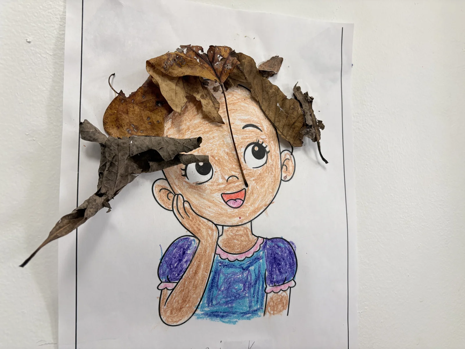 A Laurel art project combining a drawing with autumn leaves