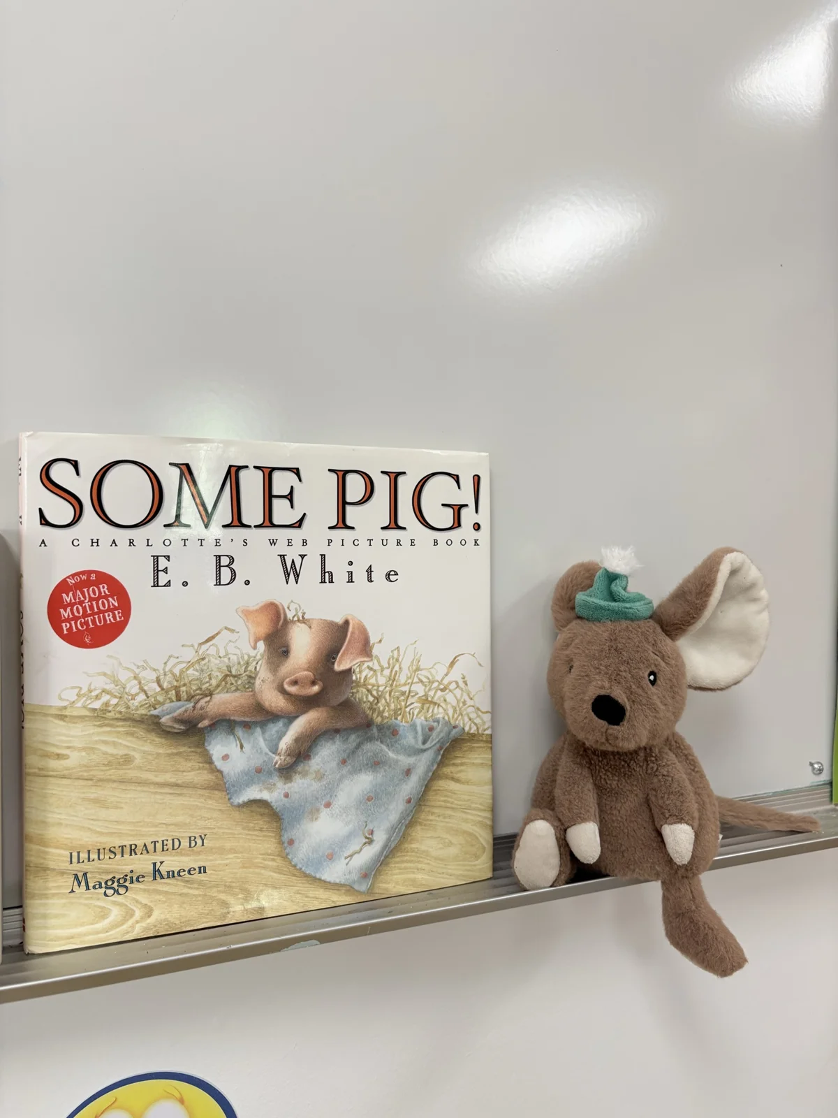 Some Pig! by E. B. White displayed on a classroom shelf beside a stuffed mouse