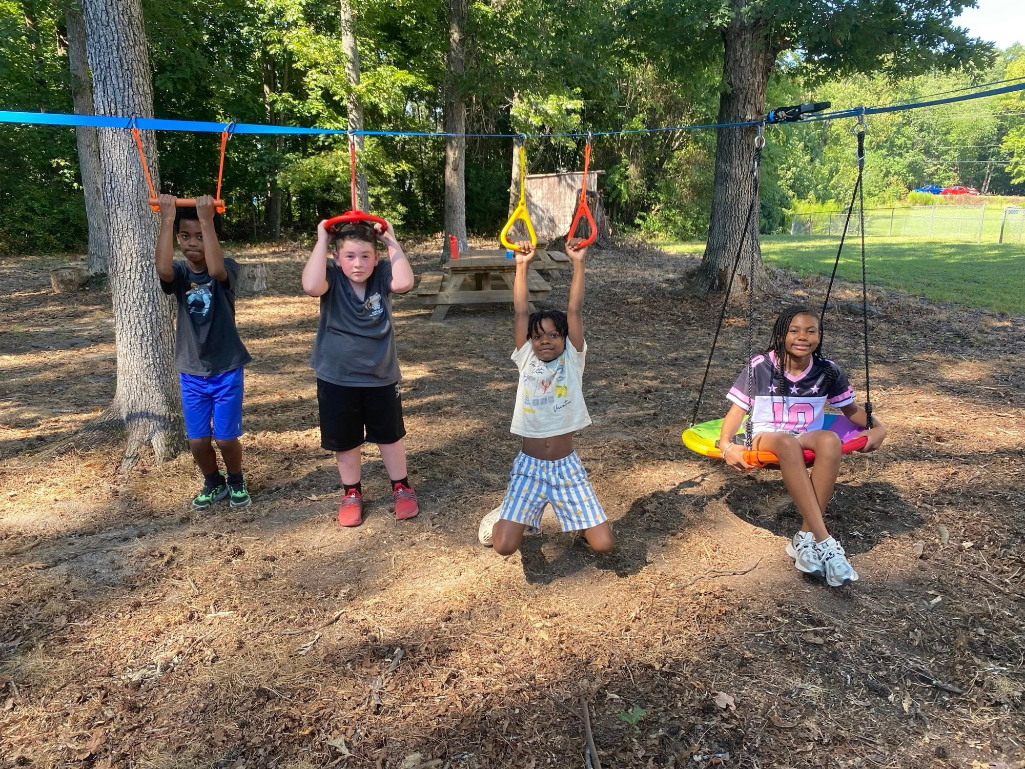 Students playing on an outdoor obstacle course at The Laurel School